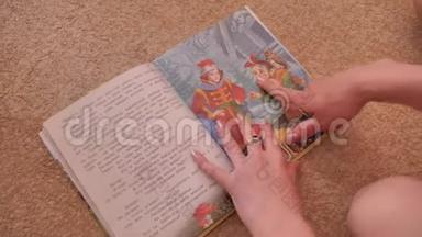女孩在地板上翻阅一本五颜六色的书。 她翻开书页，看着课文。 培训。
